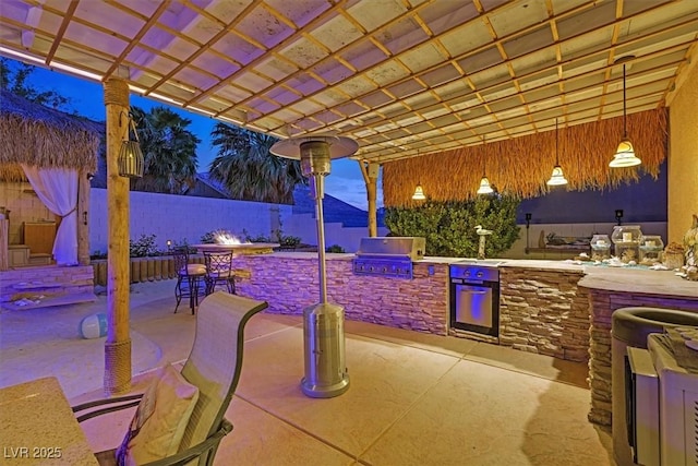 view of patio / terrace featuring area for grilling, exterior kitchen, fence, and a pergola