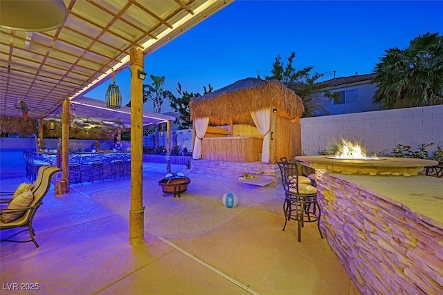view of patio featuring an outdoor fire pit, a fenced backyard, and a pool