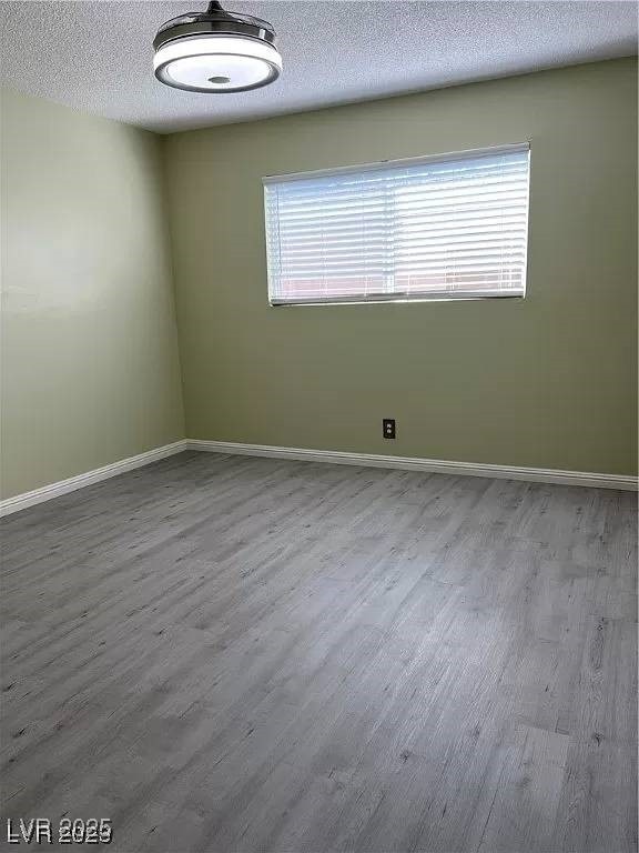 212 Orland St Unit 22, Las Vegas, NV 89107 - empty room with wood finished floors, baseboards, and a textured ceiling