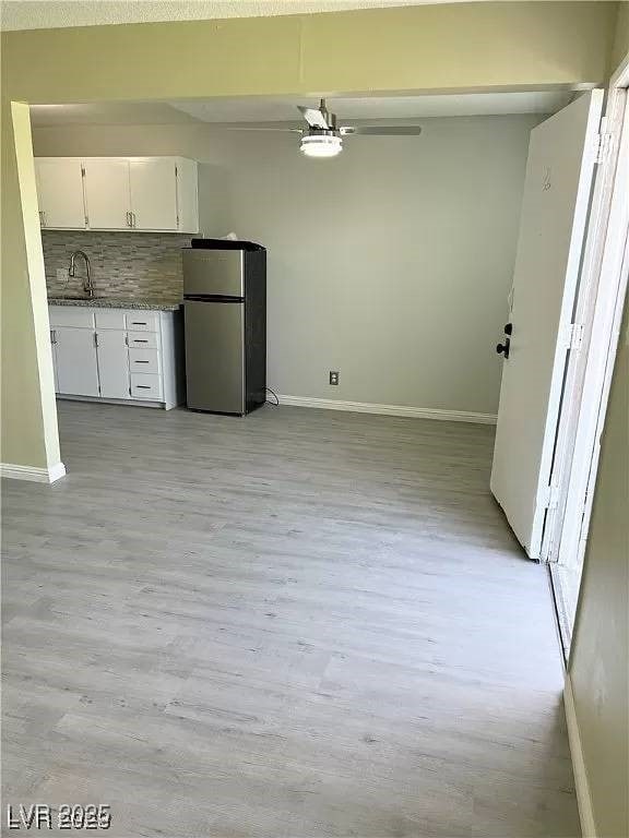 212 Orland St Unit 22, Las Vegas, NV 89107 - kitchen with freestanding refrigerator, baseboards, white cabinets, and light wood-type flooring