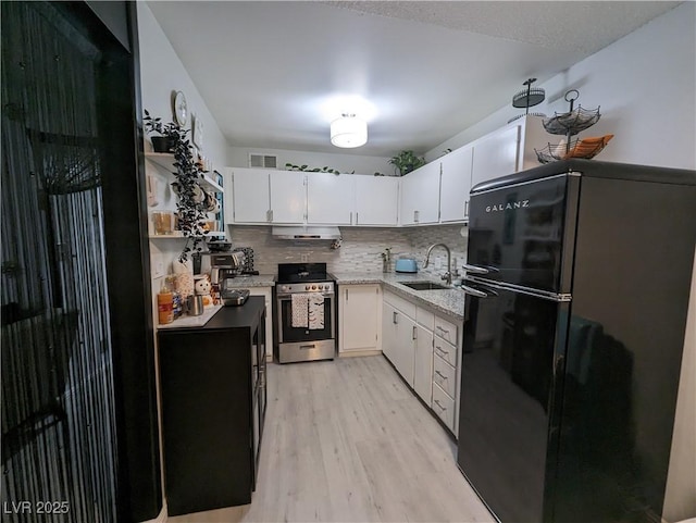 212 Orland St Unit 22, Las Vegas, NV 89107 - kitchen featuring stainless steel electric range, freestanding refrigerator, a sink, light wood-style floors, and white cabinetry