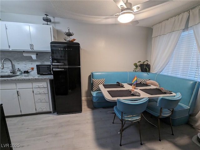212 Orland St Unit 22, Las Vegas, NV 89107 - kitchen with black appliances, a sink, decorative backsplash, a ceiling fan, and light wood-style flooring