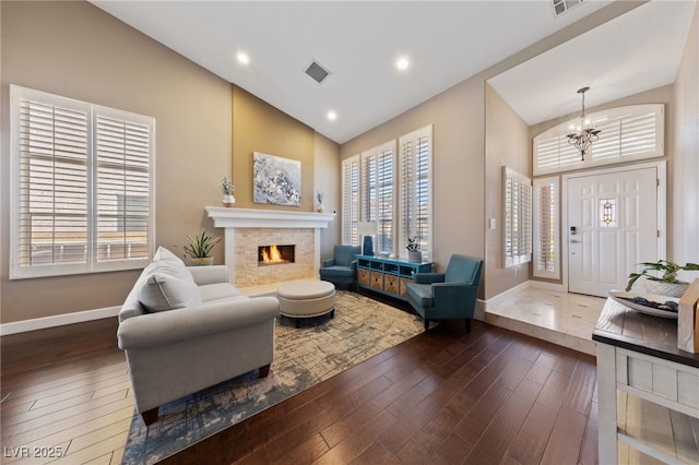 2113 Waterbury Ln, Las Vegas, NV 89134 - living area with baseboards, a chandelier, dark wood finished floors, high vaulted ceiling, and a stone fireplace