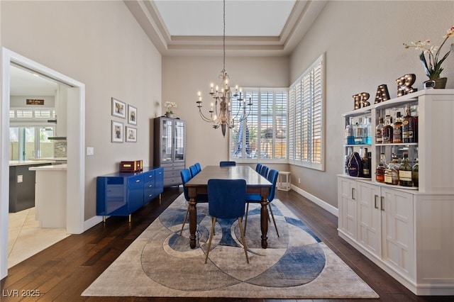2113 Waterbury Ln, Las Vegas, NV 89134 - dining space featuring dark wood finished floors, a chandelier, baseboards, and a tray ceiling
