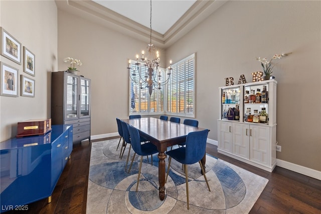 2113 Waterbury Ln, Las Vegas, NV 89134 - dining area featuring dark wood-type flooring, baseboards, a chandelier, and a high ceiling