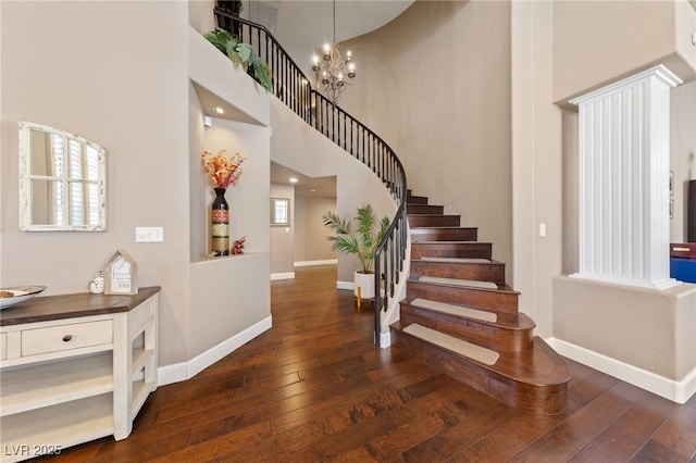 2113 Waterbury Ln, Las Vegas, NV 89134 - staircase featuring wood-type flooring, baseboards, a chandelier, and a towering ceiling