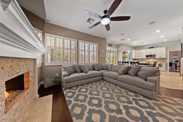 2113 Waterbury Ln, Las Vegas, NV 89134 - living room featuring a ceiling fan, light wood finished floors, a fireplace with flush hearth, recessed lighting, and baseboards
