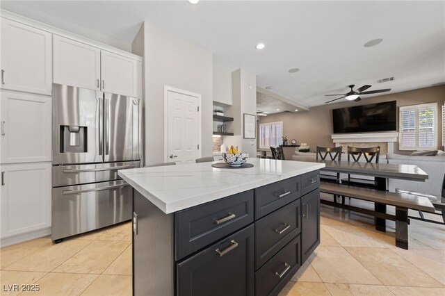 2113 Waterbury Ln, Las Vegas, NV 89134 - kitchen featuring stainless steel refrigerator with ice dispenser, white cabinetry, a ceiling fan, a center island, and light tile patterned floors