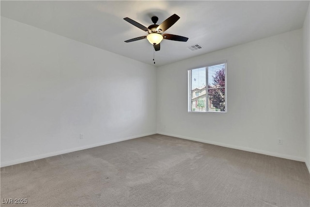 spare room featuring carpet, a ceiling fan, and baseboards