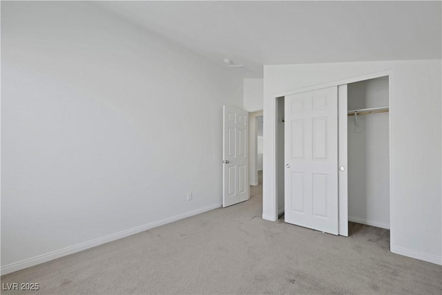 unfurnished bedroom featuring carpet flooring, baseboards, and a closet