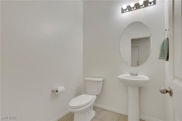 half bathroom featuring toilet, tile patterned flooring, and baseboards