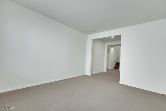 spare room featuring carpet floors, baseboards, stairway, and recessed lighting