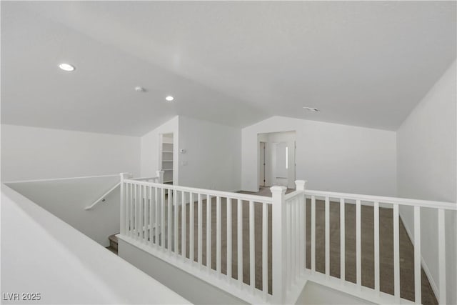 hall with an upstairs landing, lofted ceiling, and recessed lighting