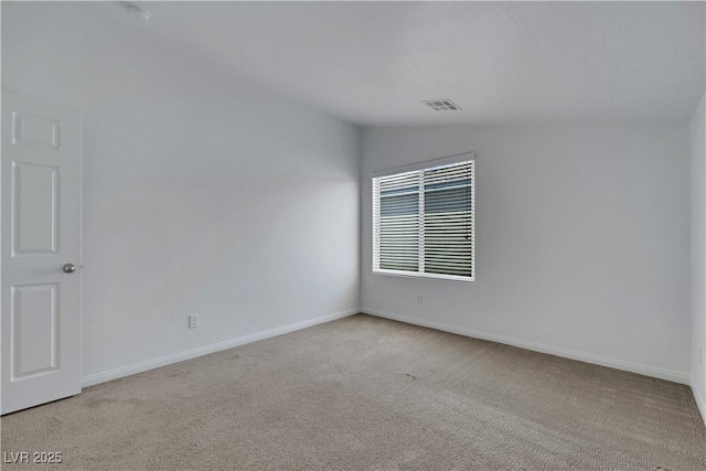 carpeted empty room featuring vaulted ceiling and baseboards