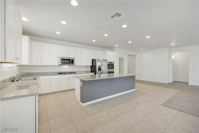 kitchen featuring stainless steel appliances, recessed lighting, a sink, a kitchen island, and light tile patterned floors