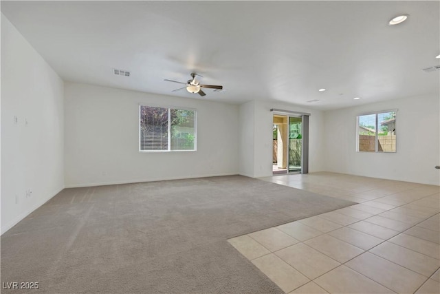 unfurnished room with ceiling fan, recessed lighting, light tile patterned floors, and light colored carpet