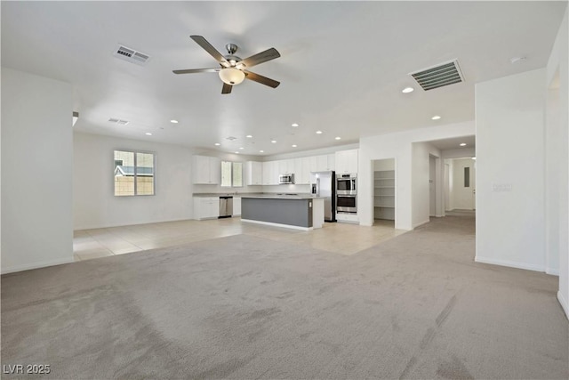 unfurnished living room featuring recessed lighting, light carpet, ceiling fan, and baseboards