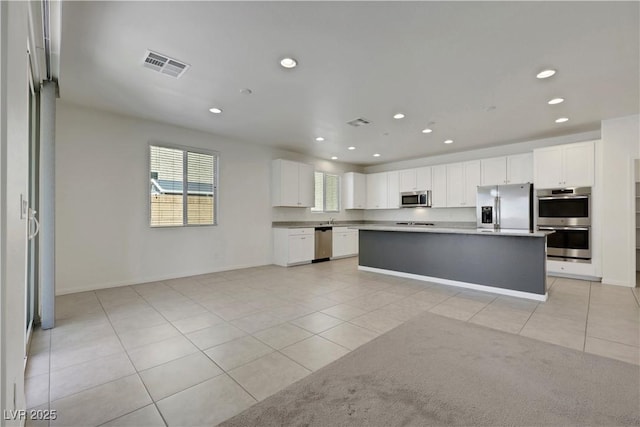 kitchen featuring stainless steel appliances, light tile patterned floors, recessed lighting, and white cabinetry