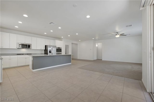 kitchen with stainless steel appliances, recessed lighting, light carpet, open floor plan, and a kitchen island with sink