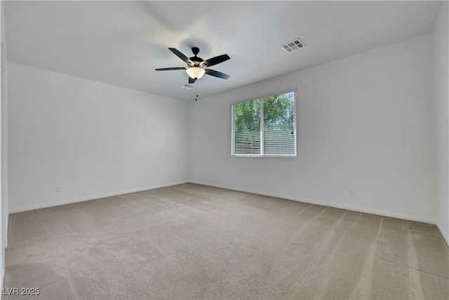 carpeted spare room with ceiling fan and baseboards