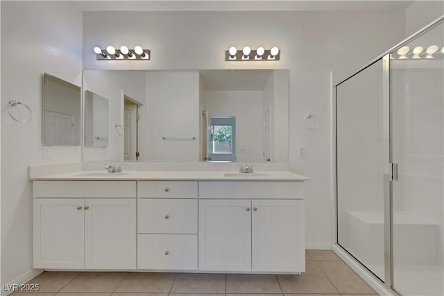 full bath featuring tile patterned flooring, baseboards, a stall shower, and double vanity