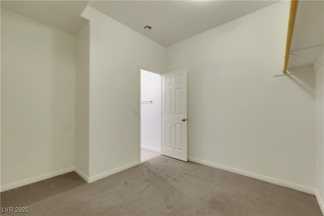 carpeted spare room featuring baseboards