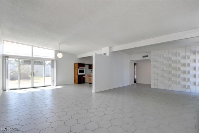 empty room featuring a textured ceiling, baseboards, and tile patterned floors