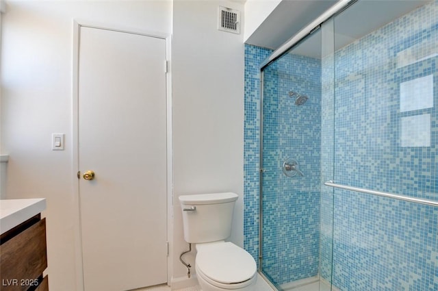 full bathroom with a stall shower, vanity, and toilet