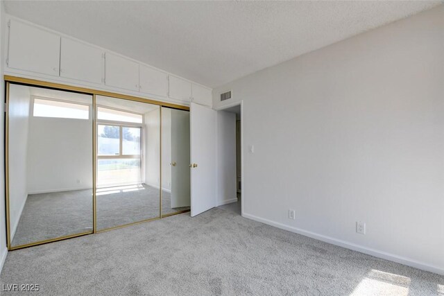 unfurnished bedroom with carpet, baseboards, and a closet