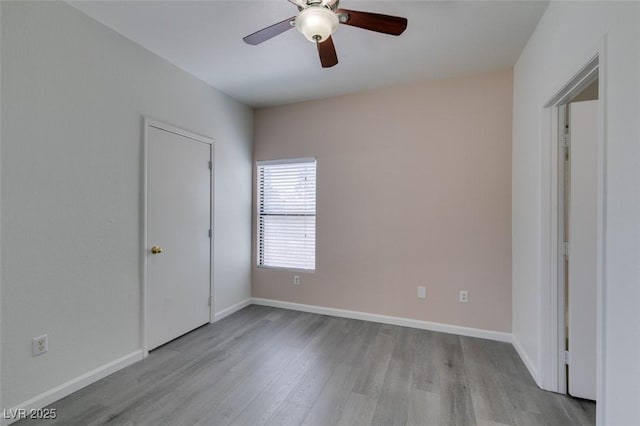 unfurnished bedroom featuring wood finished floors, baseboards, and ceiling fan