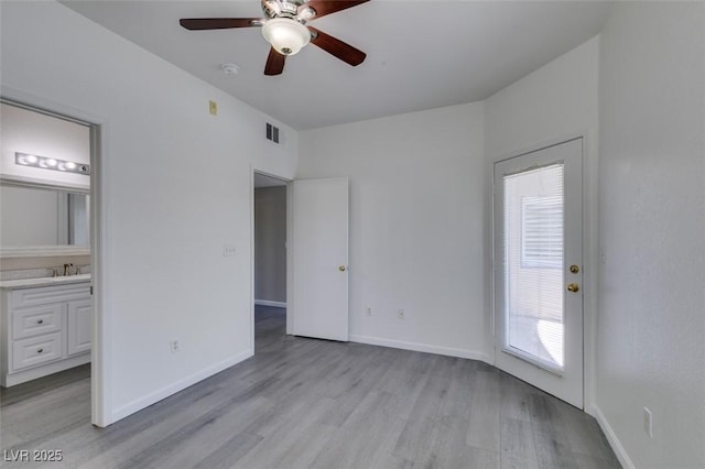 unfurnished bedroom with light wood-style floors, baseboards, connected bathroom, a sink, and ceiling fan