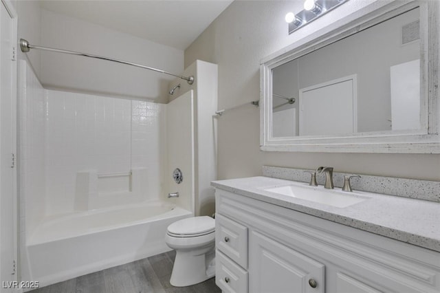 full bath featuring wood finished floors, toilet, vanity, and shower / washtub combination