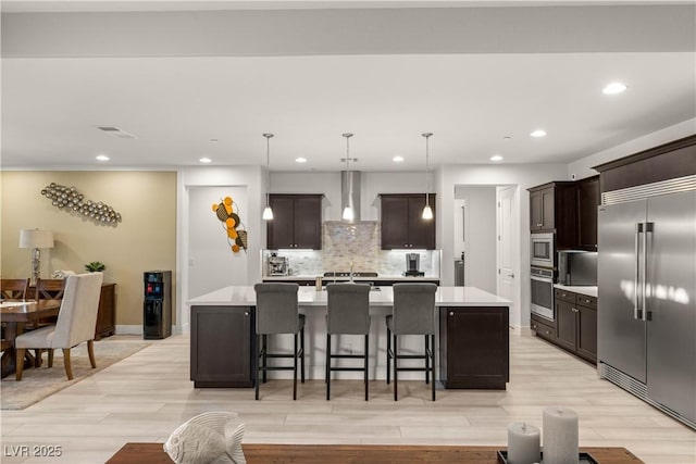4505 Amazing View St, Las Vegas, NV 89129 - kitchen featuring built in appliances, wall chimney range hood, light countertops, recessed lighting, and a large island with sink