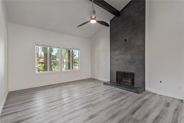 326 Fuente Dr, Henderson, NV 89014 - unfurnished living room featuring wood finished floors, beamed ceiling, a tiled fireplace, a ceiling fan, and baseboards