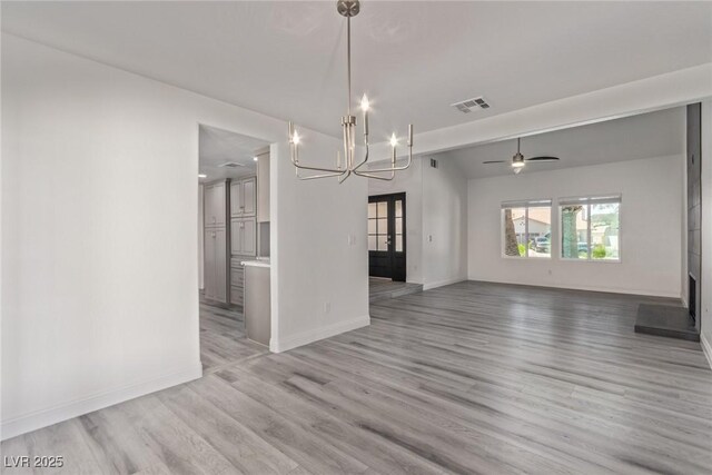 326 Fuente Dr, Henderson, NV 89014 - unfurnished living room with a chandelier, baseboards, and light wood finished floors