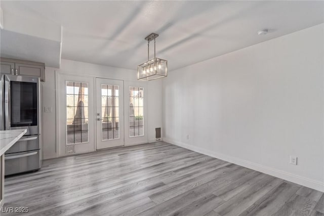 326 Fuente Dr, Henderson, NV 89014 - unfurnished dining area with light wood finished floors, baseboards, and french doors