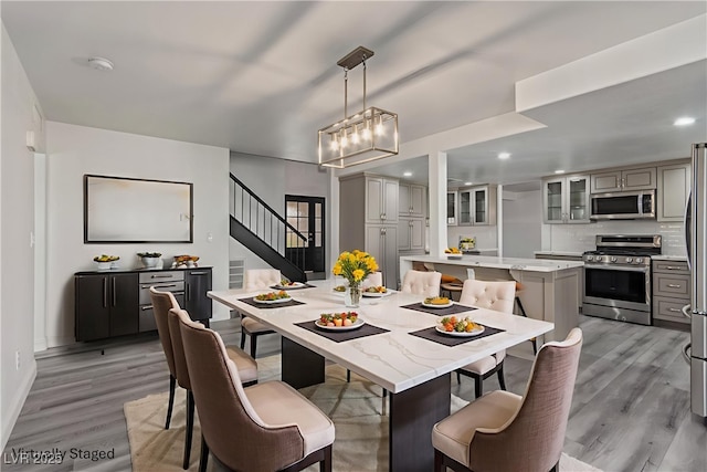 326 Fuente Dr, Henderson, NV 89014 - dining area featuring light wood-style floors, a chandelier, stairway, baseboards, and recessed lighting