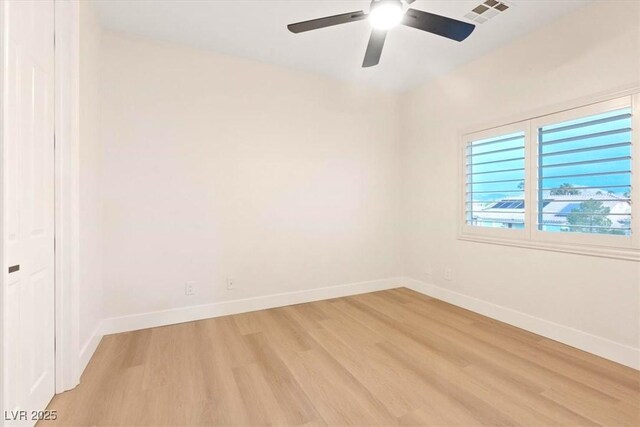 spare room with light wood finished floors, ceiling fan, and baseboards