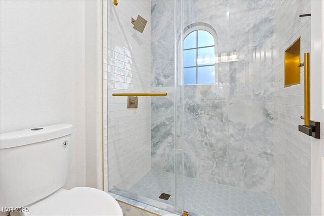 full bath featuring a stall shower and toilet