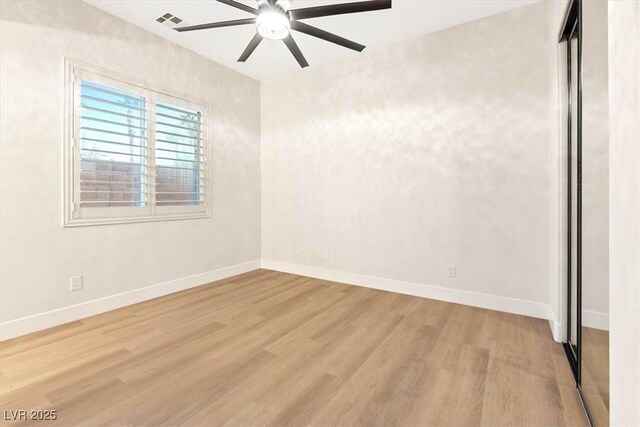 empty room with wood finished floors, ceiling fan, and baseboards