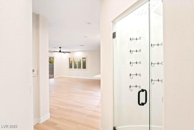 corridor featuring light wood-style flooring and baseboards