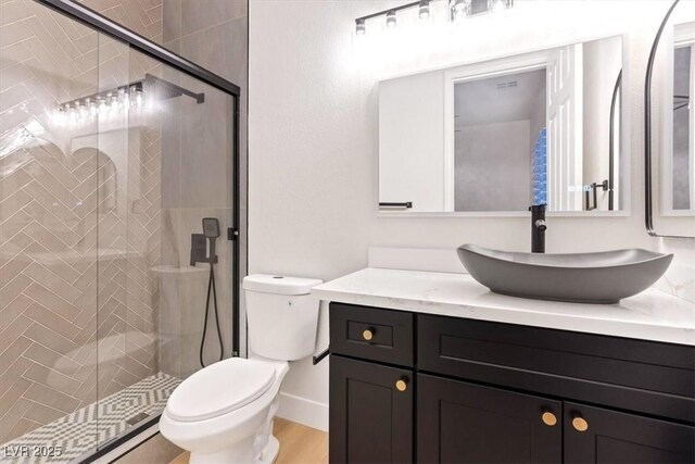 full bath with toilet, a stall shower, vanity, and wood finished floors