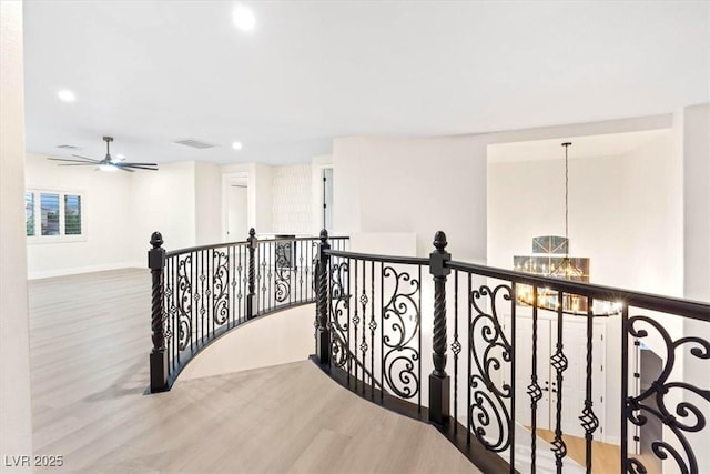hallway with wood finished floors, recessed lighting, an upstairs landing, a chandelier, and baseboards