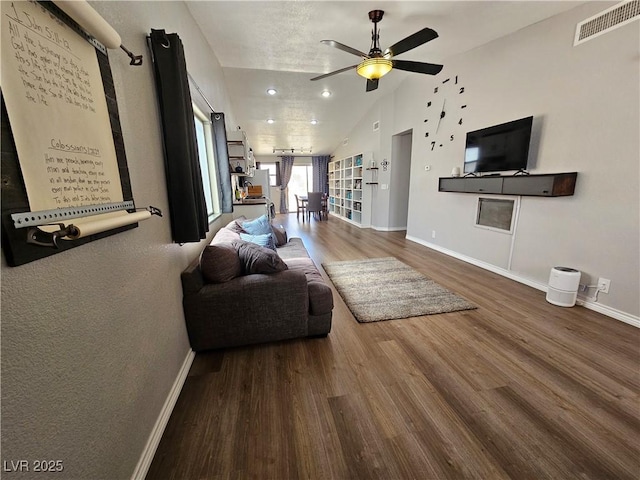 living room with lofted ceiling, wood finished floors, a ceiling fan, and baseboards