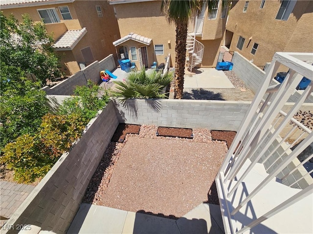 view of property's community with stairway, a fenced backyard, and a patio area