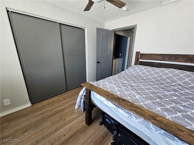 bedroom with wood finished floors, a closet, a ceiling fan, and baseboards