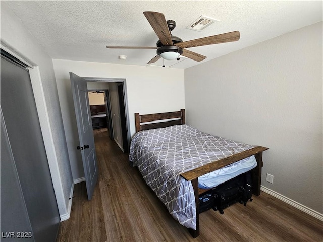 bedroom with wood finished floors, baseboards, a textured ceiling, and a ceiling fan