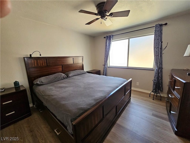 bedroom featuring dark wood finished floors, baseboards, and ceiling fan