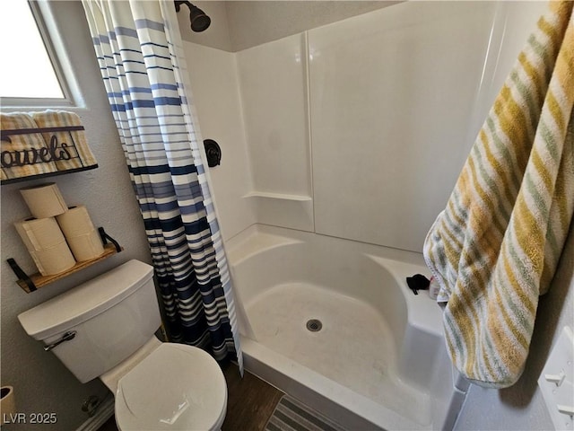 full bath featuring a shower with curtain, toilet, and wood finished floors