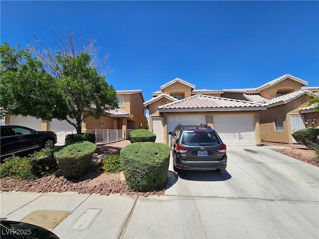 view of front of home with a garage, a tiled roof, stucco siding, and driveway